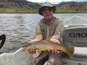 Green River Fishing Guides Report & Water Flow Flaming Gorge Dam Drift Boat Fly fishing guest of Dutch John Resort Fishing Guides releasing large green river wild trout into the tail waters below Flaming Gorge Dam into the Green River